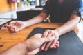 A man and a woman holding each other hands with feeling love on wooden table Royalty Free Stock Photo