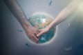 A man and a woman holding hands on the background of the globe of the planet Earth. The concept of international Association for Royalty Free Stock Photo