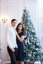 Man and woman holding hands near Christmas tree and fireplace in the Christmas atmosphere Royalty Free Stock Photo