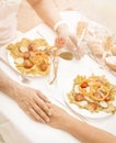 Man and woman holding hands sitting at table having romantic lunch on sandy beach Royalty Free Stock Photo