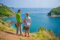 Man and woman holding hands on tropical island cliff