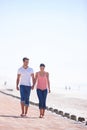 Man, woman and holding hands with walking on beach, romantic date and commitment with trust. Love, care and people Royalty Free Stock Photo