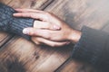 Man and woman holding hands at a wooden table Royalty Free Stock Photo