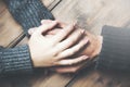 Man and a woman holding hands at a wooden table Royalty Free Stock Photo