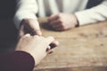 Man and a woman holding hands at a wooden table Royalty Free Stock Photo