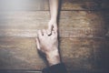 Man and a woman holding hands at a wooden table Royalty Free Stock Photo