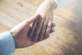 Man and a woman holding hands at a wooden table Royalty Free Stock Photo