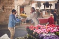 Man and woman holding together bouquet of flowers at bazaar in italy. giving and receiving concept