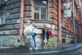 Man and woman holding umbrellas in a windy day laughing against the backdrop of an old house Royalty Free Stock Photo