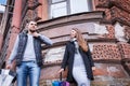 Man and woman holding umbrellas in a windy day laughing against the backdrop of an old house Royalty Free Stock Photo