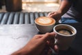 A man and a woman holding white coffee mugs in cafe Royalty Free Stock Photo