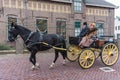 Man and woman at horse-drawn carriage during Dutch festival Urk