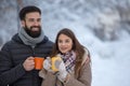 Man and woman with hot drink on snow Royalty Free Stock Photo