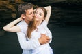 Man and woman hug with smile on black beach background