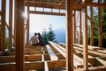 Man and woman inspecting their future wooden frame house nestled in the mountains near forest. Royalty Free Stock Photo