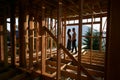 Man and woman inspecting their future wooden frame house nestled in the mountains near forest. Royalty Free Stock Photo