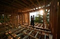 Man and woman inspecting their future wooden frame house nestled in the mountains near forest. Royalty Free Stock Photo