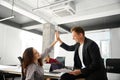 Man and woman interchanging high five after successful work plan discussion