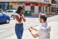 Man and woman interracial couple having engagement proposal at street Royalty Free Stock Photo