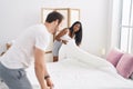 Man and woman interracial couple making bed at bedroom Royalty Free Stock Photo