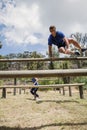 Man and woman jumping over the hurdles during obstacle course