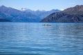 Man and woman kayaking in the beautiful natural lake in the summer heat season,surrounded with mountains and forest background Royalty Free Stock Photo