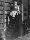 Man with woman on ladder in library Royalty Free Stock Photo