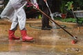 Man and woman cleaning pavement in their garden with water and brush Royalty Free Stock Photo