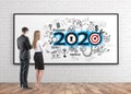 Man and woman looking at 2020 business sketch