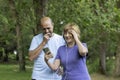 Man and woman looking surprised at a meme on the mobile phone while listening to music with headphones Royalty Free Stock Photo