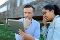 man and woman looking at tablet stood outside property Royalty Free Stock Photo