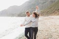 Man and woman in love enjoying together near sea, running by the beach, laughing Royalty Free Stock Photo