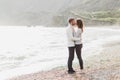 Man and woman in love enjoying together near sea, running by the beach, laughing Royalty Free Stock Photo