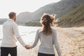 Man and woman in love enjoying together near sea, running by the beach, laughing Royalty Free Stock Photo