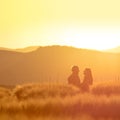 Man and woman in love standing in rye field during colorful summer sunrise - vintage photo with copy space Royalty Free Stock Photo