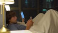 Man and woman lying in bed each with smartphone and tablet pc. problems in marriage and intersexual relationship