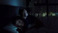 Man and woman lying in bed each with smartphone and tablet pc. problems in marriage and intersexual relationship