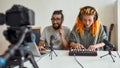 Man and woman making music using synthesizer, drum pad machine, laptop. Female and male blogger recording video blog or Royalty Free Stock Photo