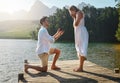 Man, woman and marriage proposal by lake on vacation with surprise, wow or happiness in sunshine. Couple, engagement and