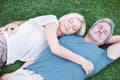 Man, woman and mature or relax on grass for afternoon nap in nature backyard for resting, weekend or sleeping. Couple Royalty Free Stock Photo