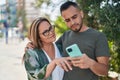 Man and woman mother and daugther using smartphone at park Royalty Free Stock Photo