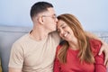 Man and woman mother and son hugging each other and kissing sitting on sofa at home Royalty Free Stock Photo