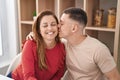 Man and woman mother and son hugging each other and kissing sitting on table at home Royalty Free Stock Photo