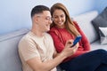 Man and woman mother and son using smartphone sitting on sofa at home Royalty Free Stock Photo