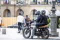 A man and a woman on a motorcycle stopped in the city square to clarify the route