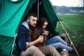 Man and woman in nature in a tent drink hot tea