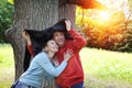 Man and the woman near an oak hide from a rain in the summer day Royalty Free Stock Photo