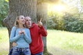 Man and woman near an oak in summer day have seen something above on a branch and look with a smile