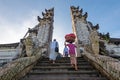 Unidentified man and woman with offering at temple gate in Pura Penataran Agung Lempuyang Bali, Indonesia