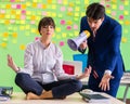 Man and woman in the office with many conflicting priorities in Royalty Free Stock Photo